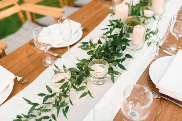 istock setting a wedding banquet in the forest. Rustic style. Green branch and candles. Celebrating a wedding 1318493707