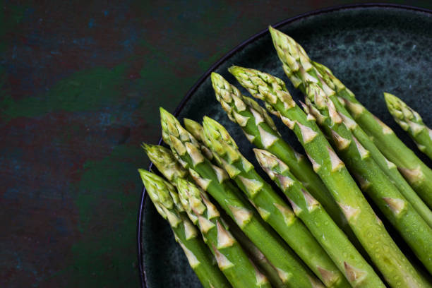 istock Raw fresh asparagus on rustic green background, top view 1318493803