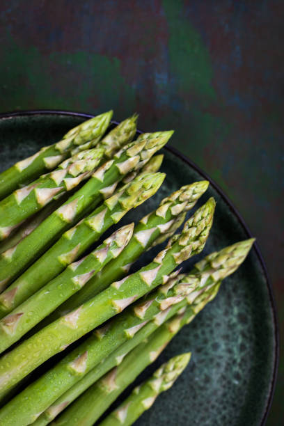 istock Raw fresh asparagus on rustic green background, top view 1318493806