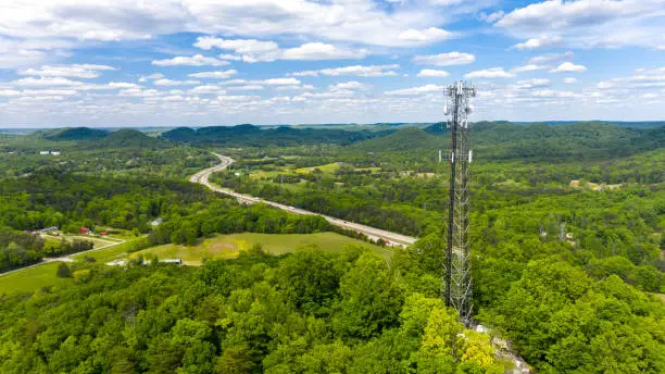 Photo of Telecommunication tower with antennas for 5g network in forest setting