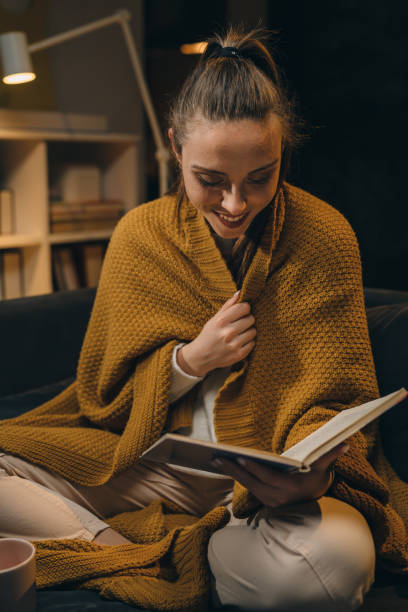 istock woman reading book at home 1318498512