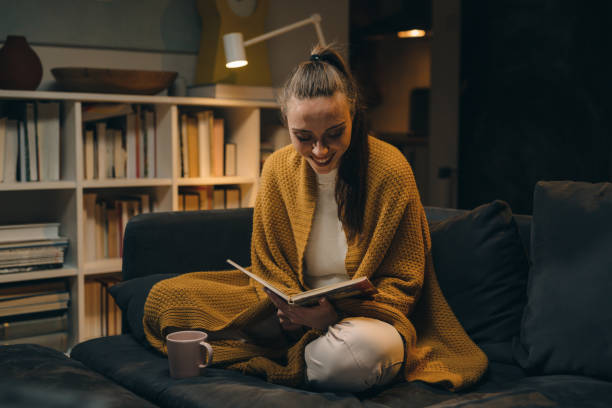 istock woman reading book at home 1318498514