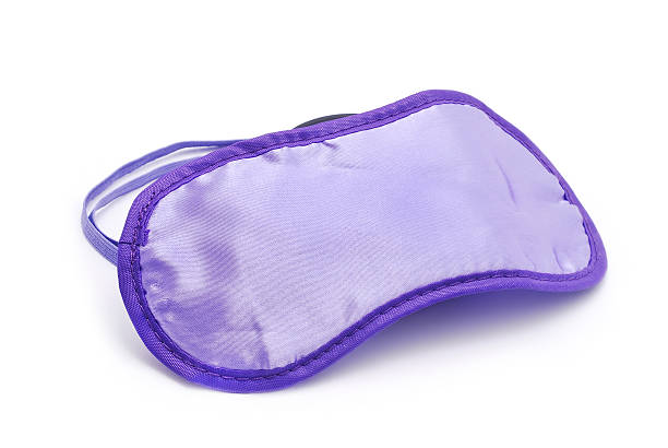 Purple sleeping mask against white background stock photo