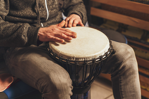 The drummer plays the ethnic percussion musical instrument djembe.