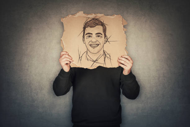 Anonymous man covers his head with a fake mask, hiding emotions behind a torn cardboard sheet with another face expression sketch drawing. Incognito person wanted. Introvert person, hidden identity un hombre anónimo se cubre la cabeza con una máscara falsa, ocultando emociones detrás de una sábana de cartón desgarrada con otro dibujo de boceto de expresión facial. se quería a una persona de incógnito. persona introvertida, identidad oculta