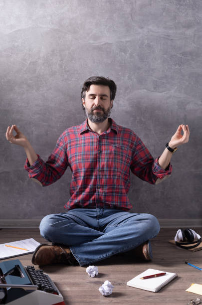istock Man meditating on floor thinking idea or relaxing. Writer or screenwriter with typewriter and paper. Creative concept 1318505096