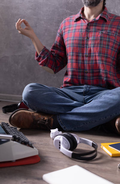istock Man meditating on floor thinking idea or relaxing. Writer or screenwriter with typewriter and paper. Creative concept 1318505183