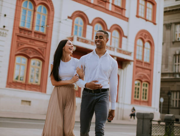 istock Young multiethnic couple walking on the street 1318505637