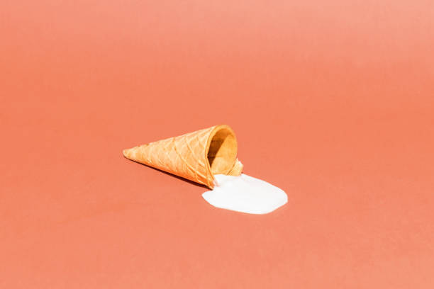 istock A cone with melted ice cream on a bright red background. Minimalistic summer food concept 1318506316