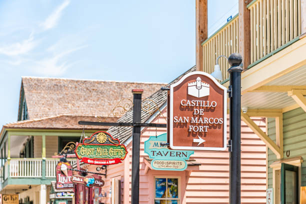 晴れた日のセントジョージストリートは、店屋とダウンタウンの旧市街フロリダ市のカスティージョ・デ・サンマルコスフォートの看板で - st augustine florida usa fort ストックフォトと画像