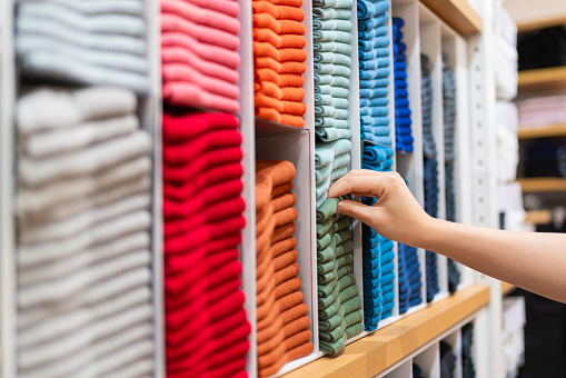 istock close up mujer mano elegir calcetines de algodón de colores en el estante en la tienda de ropa 1318518992