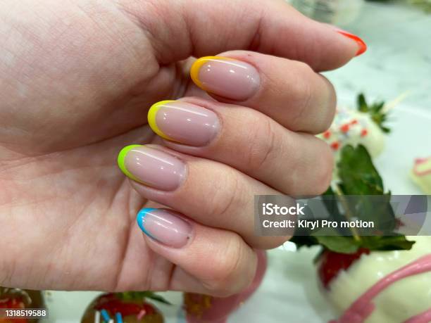 虹透明の黄色い赤い緑の青の異なる色のゲルニスと指の美しい多色の女性のマニキュアファッショナブルなスタイリッシュなフランス語スタイリッシュなネイルデザイン - 手の爪のストックフォトや画像を多数ご用意