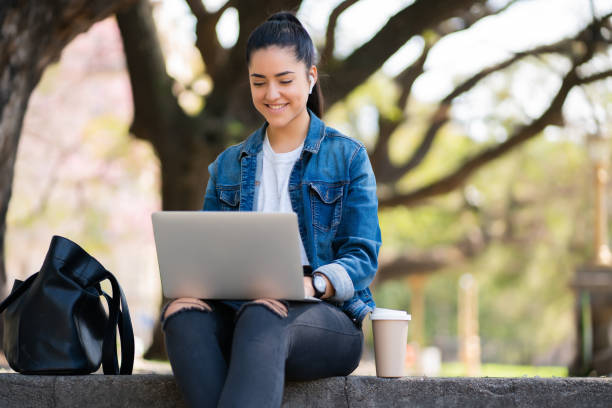 istock Woman using her laptop outdoors. 1318519642