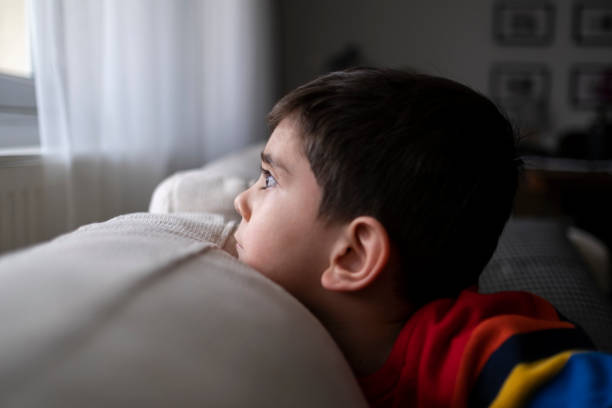 istock Quarantine, a boy looks out the window 1318520313