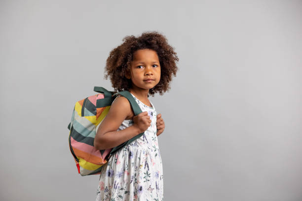 istock Little Girl With Backpack Looking At Camera 1318524713
