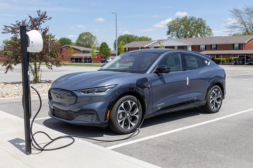 Kokomo - Circa May 2021: Ford Mustang Mach-E SUV display at a charging station. The Mustang Mach-E is Ford's first all-electric crossover and has a range of up to 300 miles.