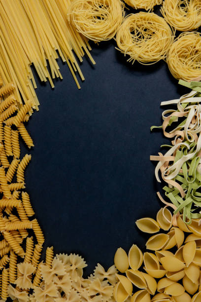 istock Assortment of different types of pasta dry on black background. 1318526791