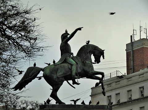 Buenos Aires, Argentina - March 10 , 2018.Monument to General San Martín and the Armies of the independence at the Plaza San Martin Square in Buenos Aires city.The Monument to General San Martín and the Armies of Independence of the city of Buenos Aires is an equestrian monument in bronze on a polished red granite base that honors General José de San Martín, Argentine national hero.\nMonument inaugurated on July 13, 1862, the work of the French sculptor Louis-Joseph Daumas.
