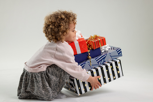 Happy little boy in blue Christmas hat with a gift box copy space. Empty place for your text. Winter holidays and present concept