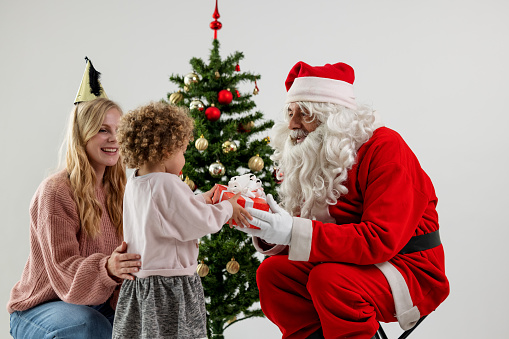 Young Girl Meeting Santa Claus With Her Mom