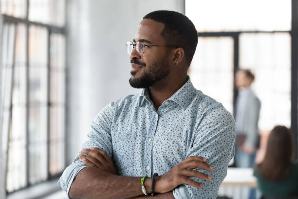 Successful African American startup leader looking out window