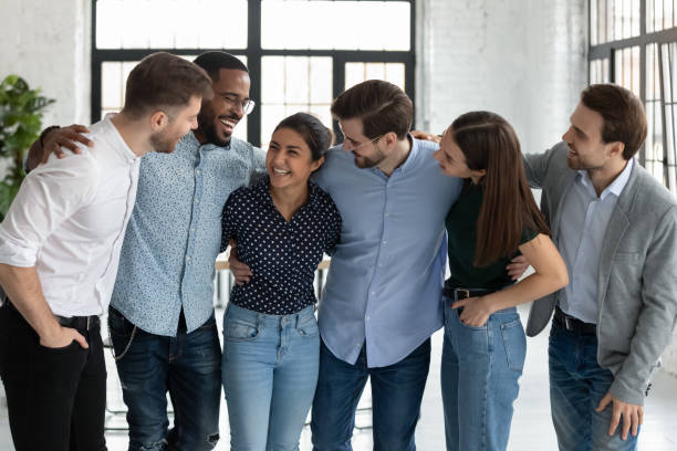 istock Excited diverse group of employees hugging, laughing, celebrating 1318531436
