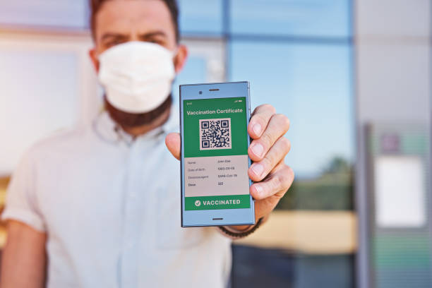 istock Hand man holding smartphone displaying on app mobile valid digital green vaccination certificate for Covid-19 1318532055