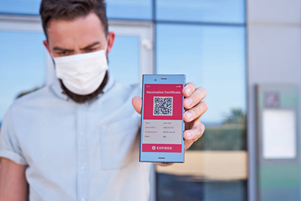 istock Man holding smartphone displaying on app mobile expired digital vaccination certificate for Covid-19 1318532057