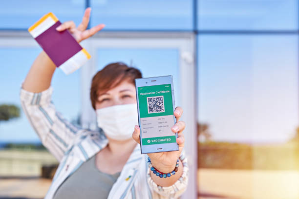 istock Happy woman holding smartphone displaying on app mobile valid digital green vaccination certificate for Covid-19. 1318532070