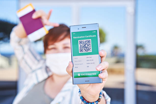 istock Happy woman holding smartphone displaying on app mobile valid digital green vaccination certificate for Covid-19. 1318532071