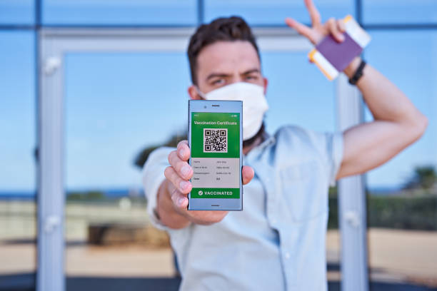 istock Hand man holding smartphone displaying an app mobile valid digital green vaccination certificate for Covid-19 1318532075