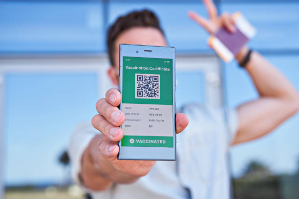 istock Hand man holding smartphone displaying on app mobile valid digital green vaccination certificate for Covid-19 1318532080