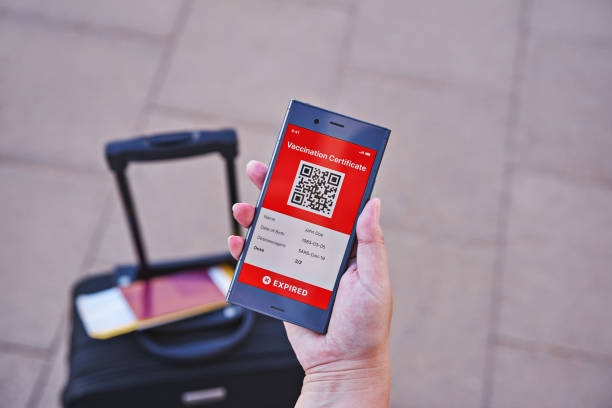 istock Smartphone in hand displaying on app mobile expired digital green vaccination certificate for Covid-19 1318532100