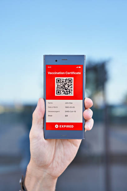 istock Hand man holds smartphone displaying an app mobile expired digital vaccination certificate for Covid-19, closeup 1318532133