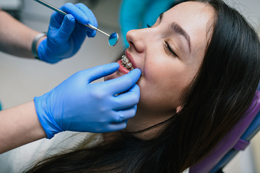 A young girl is having a denture adjustment at her dentist.