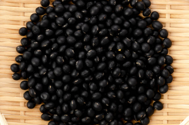 istock uncooked black beans on bamboo sieve on white background 1318533436