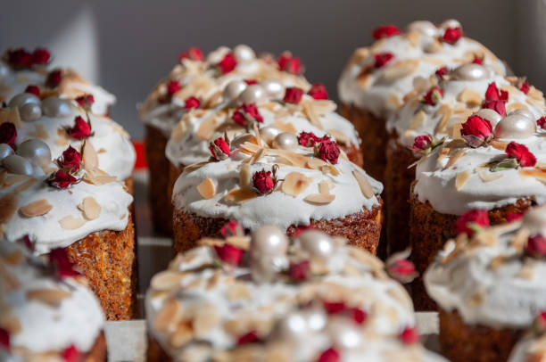 istock Delicious easter cakes with sprinkles and frosting. Easter cakes decorated with sweet sugar icing, dried little rose flowers and almond roasted flakes 1318536803