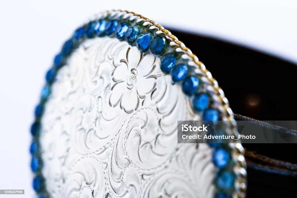 Silver Belt Buckle with Blue Rhinestones Detail Silver Belt Buckle with Blue Rhinestones Detail - Scrollwork detail on belt closeup macro photo with shallow depth of field. Leather Stock Photo