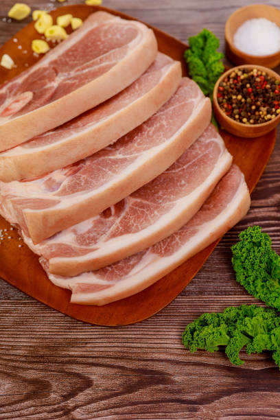 istock Sliced raw pork shoulder with spices on wooden board. 1318539765