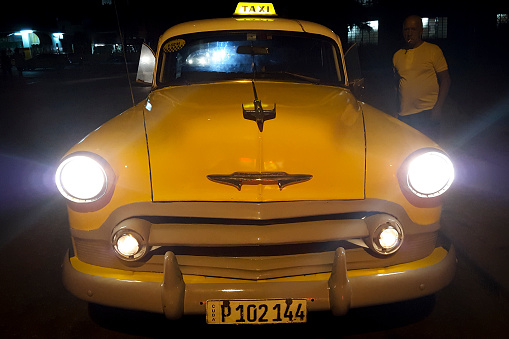 Old car used as one of the traditional yellow taxis that circulate in the city of Havana