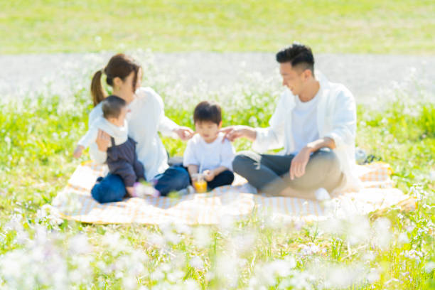 istock Parents and children enjoying a picnic (focus is on the grass in front of the person) 1318549811
