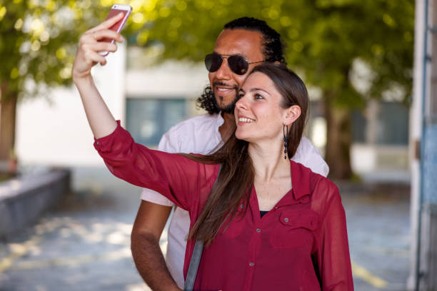 istock Mixed Race Heterosexual Couple Taking A Selfie Using Smart Phone 1318555342