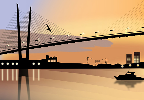 Suspension bridge across a sea bay at the golden hour reflecting in sea waters with sea port cranes and buildings on the horizon