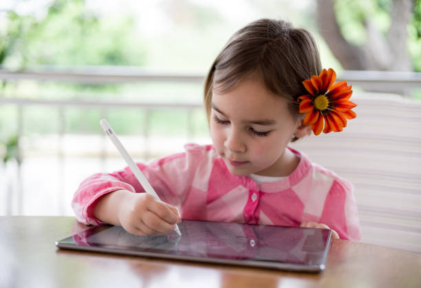 istock Child Girl Drawing Pictures Using Digital Tablet 1318557952