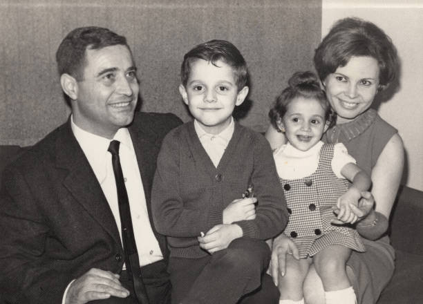 винтажное изображение, сделанное в 60-х: улыбающаяся зрелая пара позирует со своими детьми - caucasian child offspring color image стоковые фото и изображения