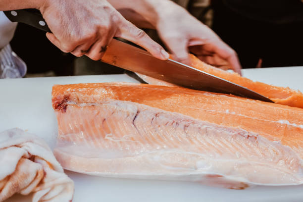 istock Professional chef preparing a fresh salmon on a cutting board. 1318561193