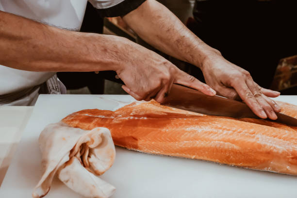 istock Professional chef preparing a fresh salmon on a cutting board. 1318561202