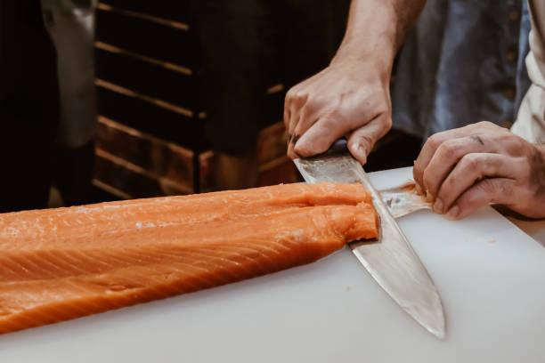 istock Professional chef preparing a fresh salmon on a cutting board. 1318561246