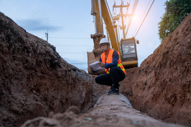 inżynier zużycie munduru bezpieczeństwa badania wykopu wodociągów lub rurociągu kanalizacyjnego - earth mover digging land bulldozer zdjęcia i obrazy z banku zdjęć