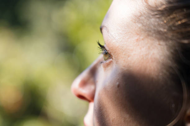 A beautiful woman close up looking outside, green forest nature background